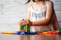 Portrait Of Beautiful Thoughtful Little Girl Playing Colorful Magnet Plastic Blocks Kit, Daydreaming And Creating Picture Ideas In