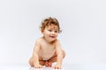 Portrait of beautiful toddler boy, baby in diaper crawling isolated over white studio background. Happy child Royalty Free Stock Photo