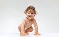 Portrait of beautiful toddler boy, baby in diaper crawling isolated over white studio background. Happy child Royalty Free Stock Photo