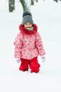 Portrait of a beautiful toddler girl playing outdoors with snow. Happy little child enjoying a winter day in the park or