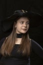 Portrait of beautiful toung woman in black wide-brimmed hat. Stylish young lady. Vertical frame. Modern witch. Halloween