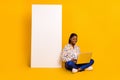 Portrait of beautiful trendy cheery girl sitting using laptop copy blank space eshop app isolated over bright yellow