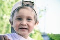 Portrait of a beautiful two year old baby in a baseball cap. A boy with blond hair is looking at the camera and smiling. Royalty Free Stock Photo