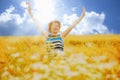 Portrait of beautiful very happy blonde woman with arms outstretched in a wheat field in summer sun`s rays Royalty Free Stock Photo