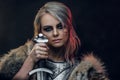 Portrait of a beautiful warrior woman holding a sword wearing steel cuirass and fur. Fantasy fashion. Cosplayer as Ciri