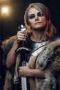 Portrait of a beautiful warrior woman holding a sword wearing steel cuirass and fur. Fantasy fashion. Cosplayer as Ciri