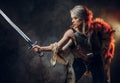 Portrait of a beautiful warrior woman holding a sword wearing steel cuirass and fur. Fantasy fashion. Cosplayer as Ciri