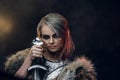 Portrait of a beautiful warrior woman holding a sword wearing steel cuirass and fur. Fantasy fashion. Cosplayer as Ciri Royalty Free Stock Photo