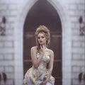 Portrait of a Beautiful woman in an ancient medieval dress, with a high complex historical hairstyle near the walls of Royalty Free Stock Photo