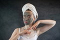 Portrait of beautiful Woman applying nourishing green clay mud mask to her face isolated on black Royalty Free Stock Photo