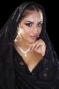 Portrait of a beautiful woman with arabian makeup in black paranja