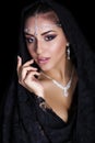 Portrait of a beautiful woman with arabian makeup in black paranja