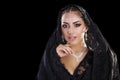 Portrait of a beautiful woman with arabian makeup in black paranja