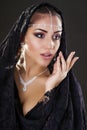 Portrait of a beautiful woman with arabian makeup in black paranja