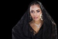 Portrait of a beautiful woman with arabian makeup in black paranja