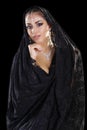 Portrait of a beautiful woman with arabian makeup in black paranja