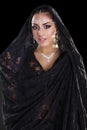 Portrait of a beautiful woman with arabian makeup in black paranja