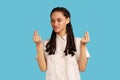 Woman with dreadlocks makes money gesture, rubs fingers, looking at camera with glad expression. Royalty Free Stock Photo