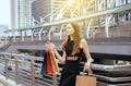 Portrait of beautiful woman in black dress smiling and holding shopping bags in center city,Lifestyle concept Royalty Free Stock Photo