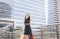 Portrait of beautiful woman in black dress smiling and holding shopping bags in city,Lifestyle concept Royalty Free Stock Photo