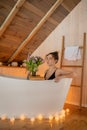 Portrait of beautiful woman in black underwear relaxing and spending weekend at home. Taking bath with glass of wine on Royalty Free Stock Photo