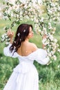 Portrait of a beautiful woman in a blooming garden. A girl in a spring garden. photo from the back