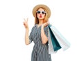 Portrait of beautiful woman blowing her lips with shopping bags wearing a summer straw round hat, black white striped dress Royalty Free Stock Photo