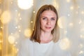 Portrait of beautiful woman with blue eyes close-up. Bokeh garlands in delicate