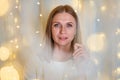 Portrait of beautiful woman with blue eyes close-up. Bokeh garlands in delicate