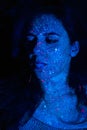 Portrait of a beautiful woman with blue sequins on her face. Girl with artistic make-up in Light color. Fashion model Royalty Free Stock Photo