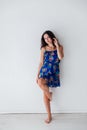 Portrait of a beautiful brunette woman in a blue summer dress with flowers on a white background Royalty Free Stock Photo