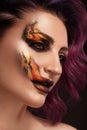 Portrait of a beautiful woman with creative fire art make-up on her face. Royalty Free Stock Photo
