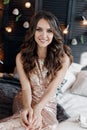 Portrait of a beautiful woman with curls at the Christmas tree with gifts of new year lights garland Royalty Free Stock Photo