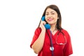 Portrait of doctor wearing scrubs talking at telephone receiver Royalty Free Stock Photo