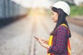 Portrait of beautiful woman engineering using tablet with wear hardhat in front of train garage