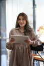 Beautiful woman entrepreneur standing at her coffee shop and using digital tablet. Royalty Free Stock Photo