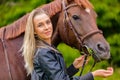 Portrait of a beautiful woman feeding her arabian horse with snacks in the field Royalty Free Stock Photo