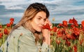 Portrait of a beautiful woman on flowering poppy field. Summer holidays on nature. Girl on poppies meadow with poppys Royalty Free Stock Photo