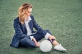 Portrait of a beautiful woman football player in a strict office suit, concept sports office manager leisure