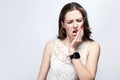 Portrait of beautiful woman with freckles and white dress and smart watch with tooth pain on silver gray background. Royalty Free Stock Photo