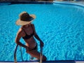 Portrait of a beautiful woman getting out of a swimming pool. beautiful blond hair tanned female model posing by blue Royalty Free Stock Photo