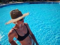 Portrait of a beautiful woman getting out of a swimming pool. beautiful blond hair tanned female model posing by blue Royalty Free Stock Photo