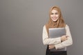 Portrait of beautiful woman with hijab is holding computer laptop on gray background Royalty Free Stock Photo