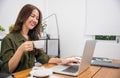 woman holding coffee mug on hand while online shopping for cyber monday sales on laptop Royalty Free Stock Photo