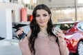 Portrait of beautiful woman holding keys from car in showroom Royalty Free Stock Photo