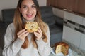 Portrait of beautiful woman holding a slice of Panettone traditional Italian cake for Christmas with raisins and candied fruits