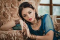 portrait of a beautiful woman in Indian traditional Chinese dress, with her hands painted with henna mehendi. Girl sitting on a l
