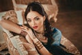 Portrait of a beautiful woman in Indian traditional Chinese dress, with her hands painted with henna mehendi. Girl sitting on a lu