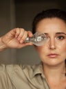 Woman holds incandescent light bulb in front of her