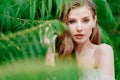 portrait. beautiful woman with light eyes in white dress against of green leaves Royalty Free Stock Photo